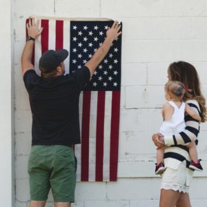 Image of a family hanging up an American flag