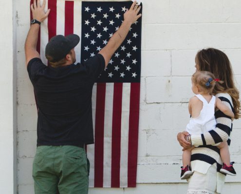 Image of a family hanging up an American flag