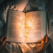 Image of a person reading a book at night