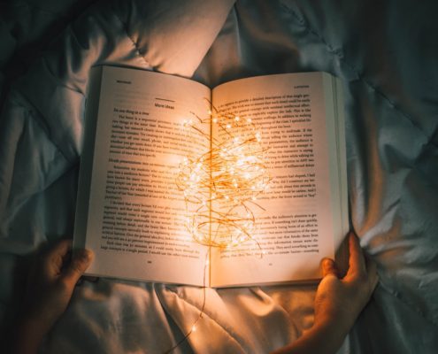 Image of a person reading a book at night